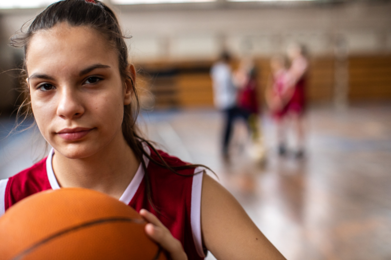 Female student playing basketball