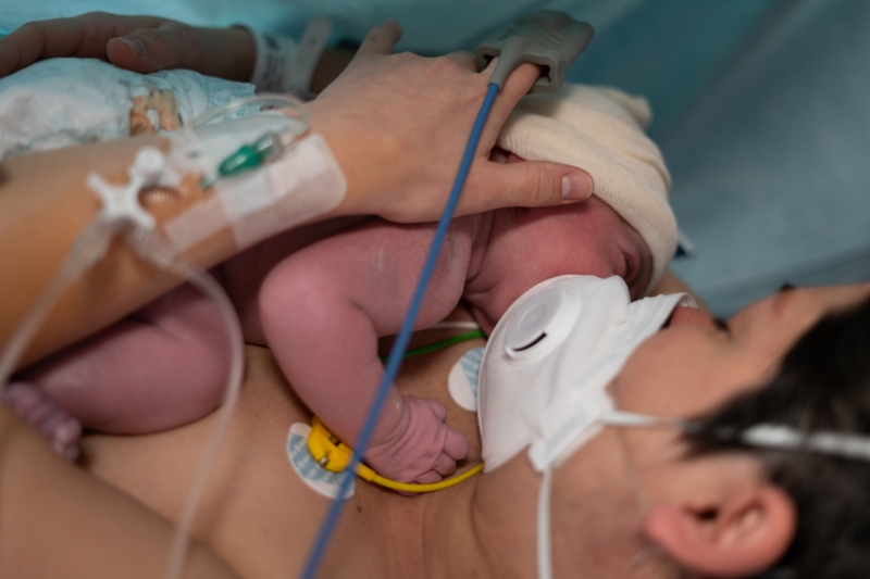 A woman cradles her newborn child.