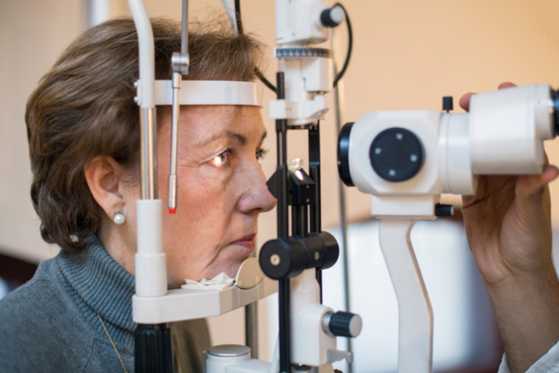 Woman looking into a eye test machine.
