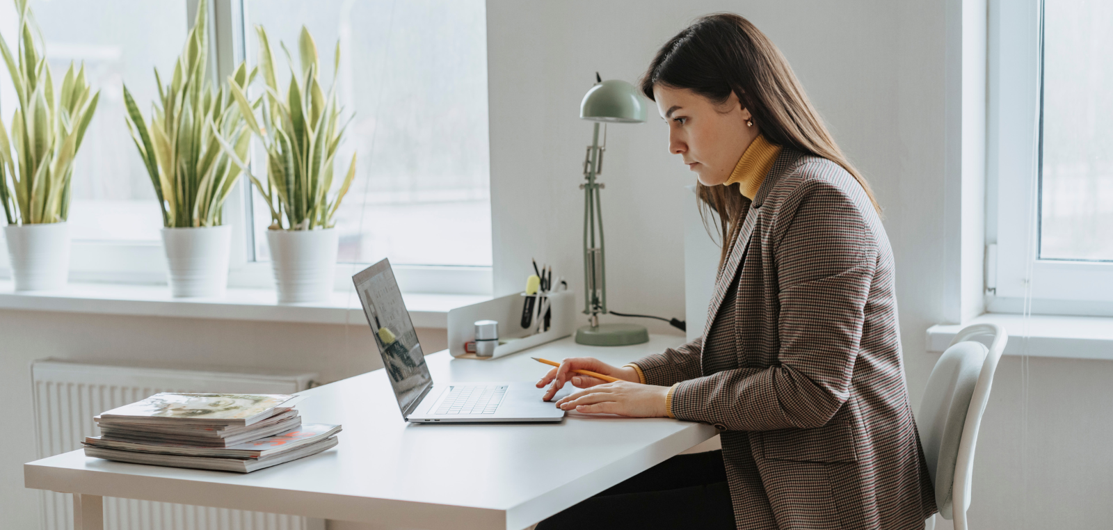 Smartly dressed woman using a laptop at a desk