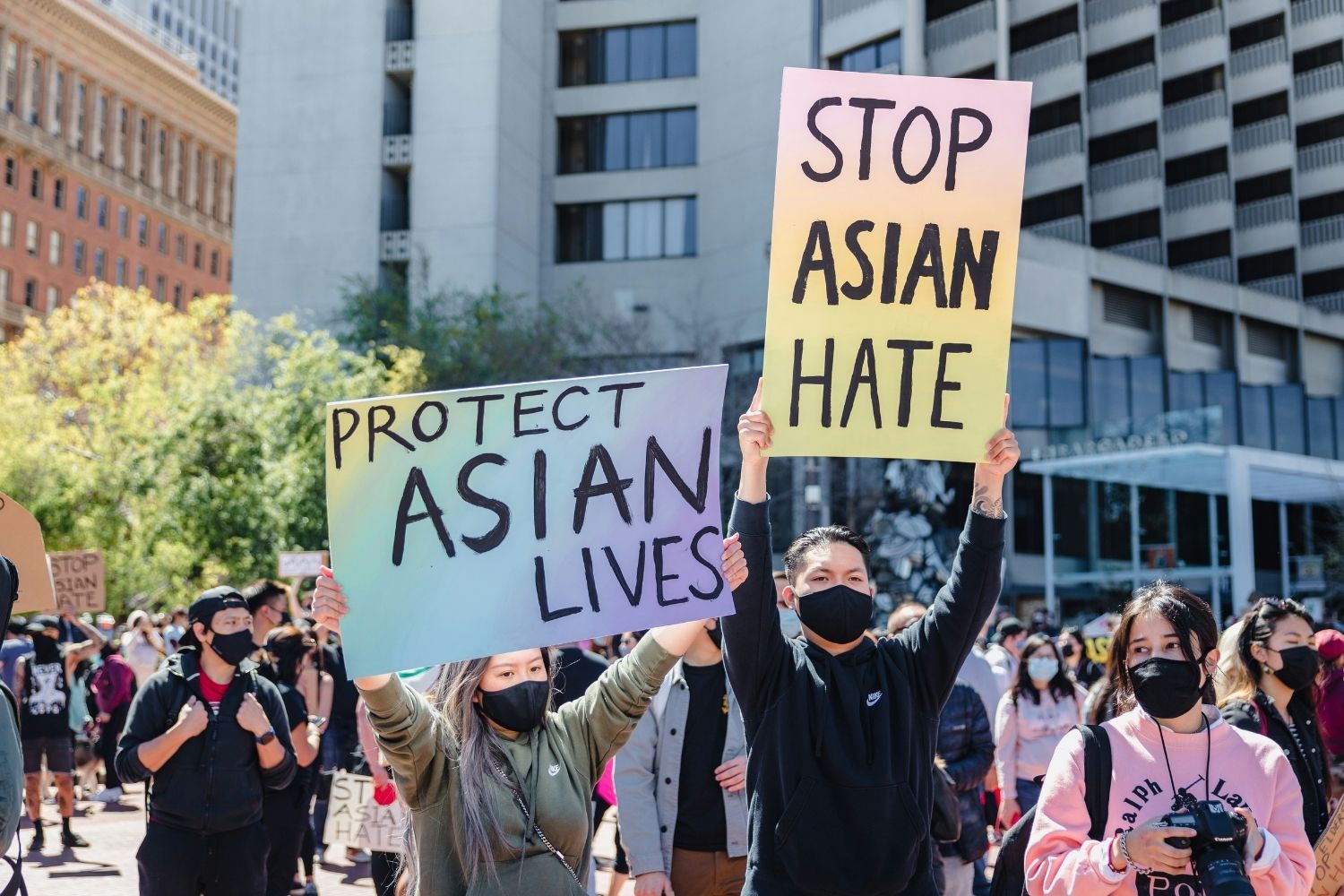 Protestors hold up signs reading "Protect Asian Lives" and "Stop Asian Hate"