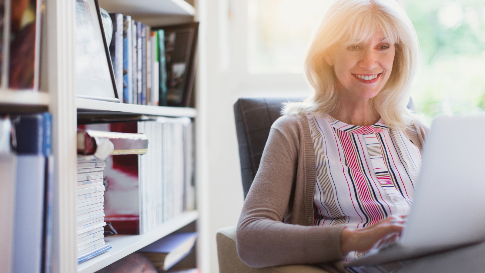 Senior woman in an armchair using a laptop