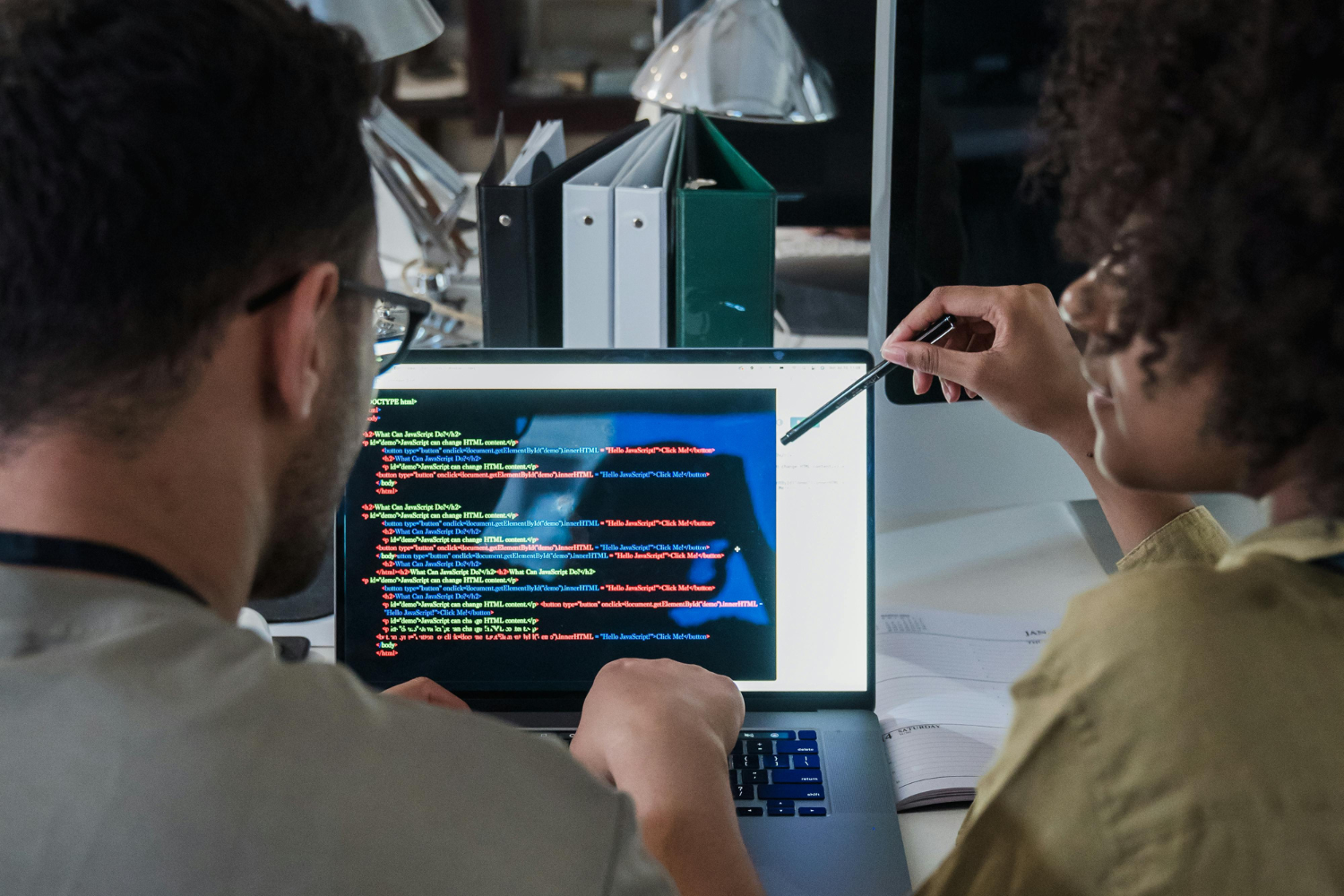 Two people coding on a laptop