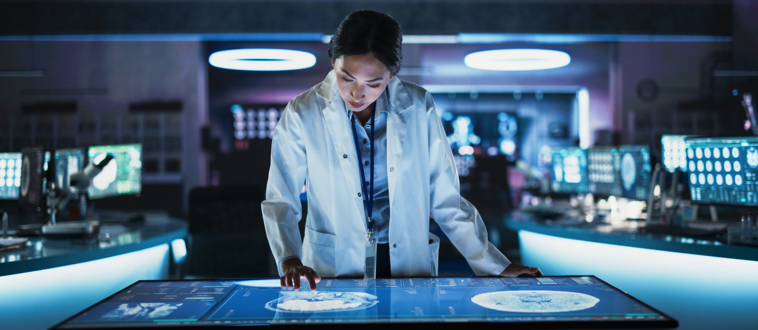 Neuroscinetist using interactive touch screen table with MRI scans on display. Doctor developing innovative devices for people with Alzheimer's.