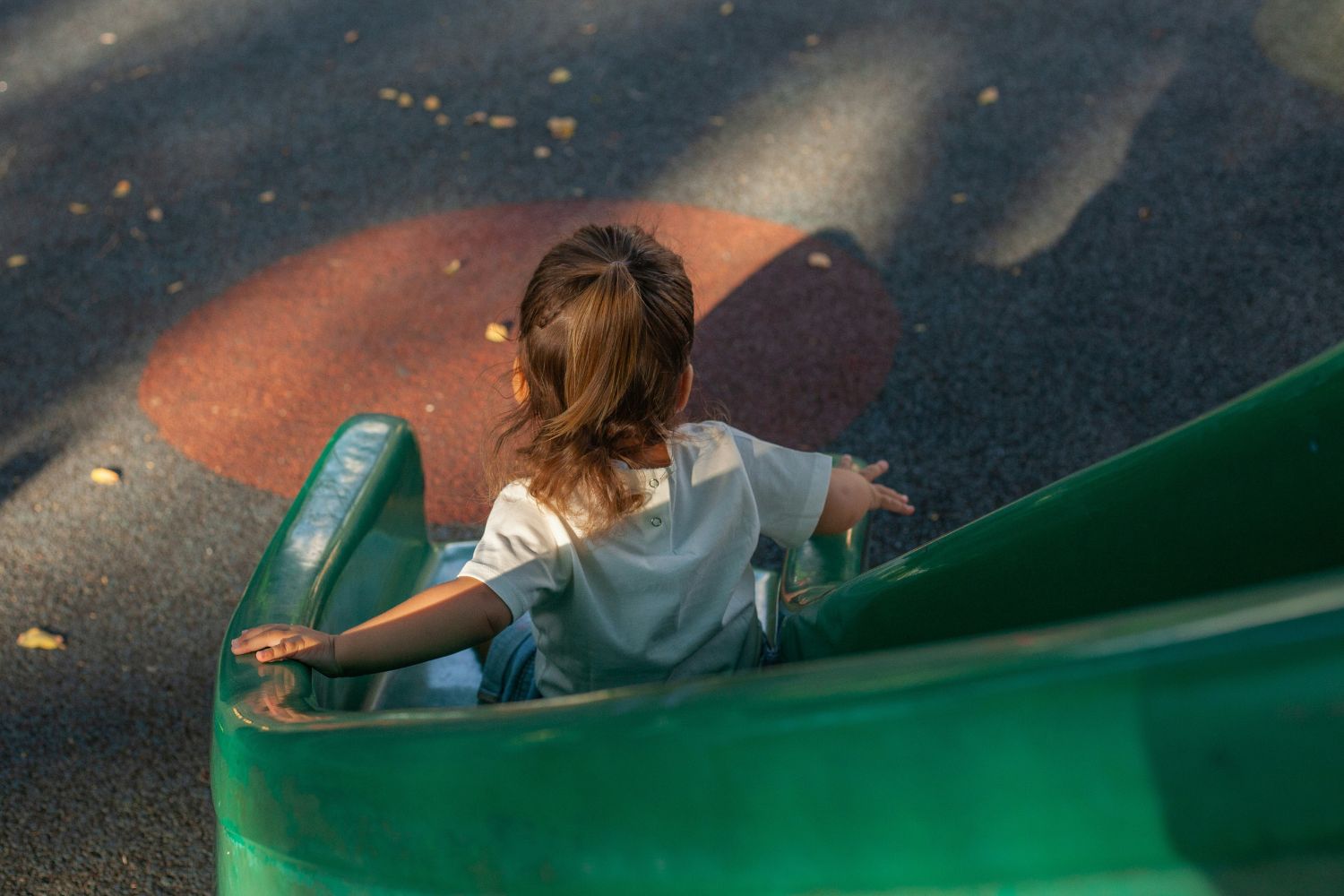 A young girl goes down a slide in a playground