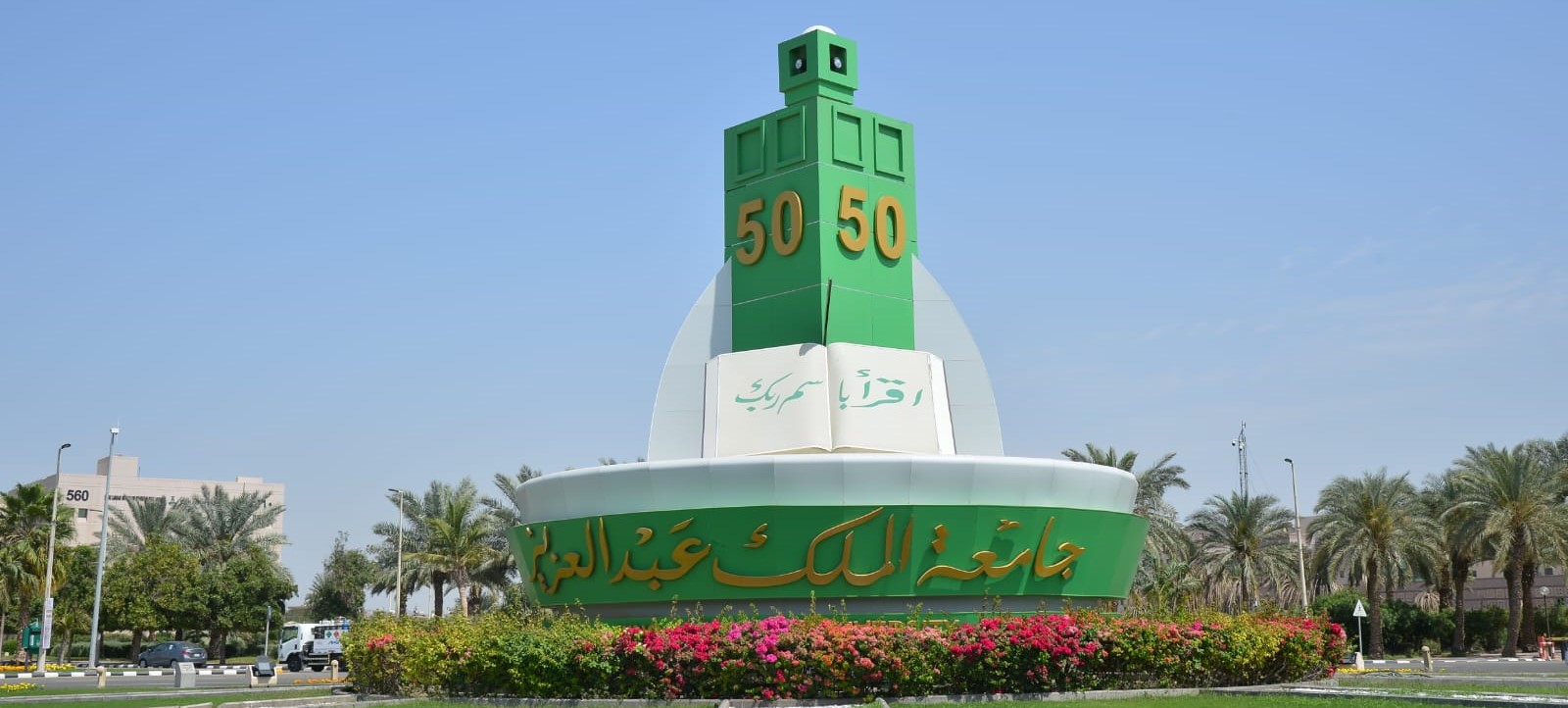 Photo of the KAU 50-Years Roundabout which has a tall green lighthouse-shaped tower in the middle with '50' on each side.