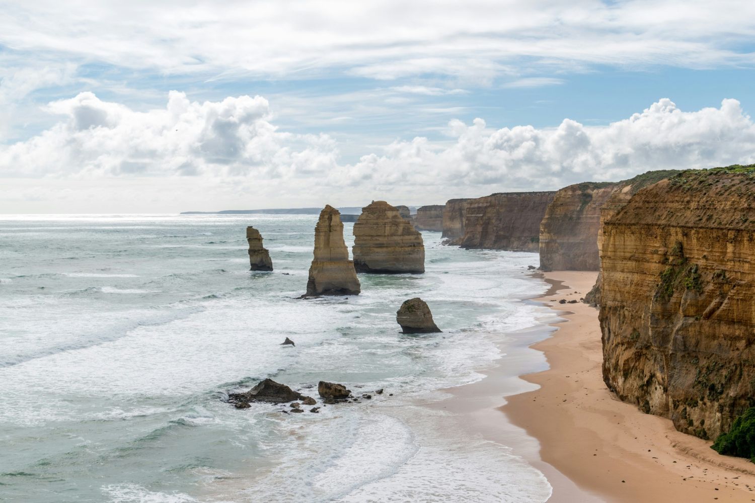 Brown rock formation on seashore in the daytime.