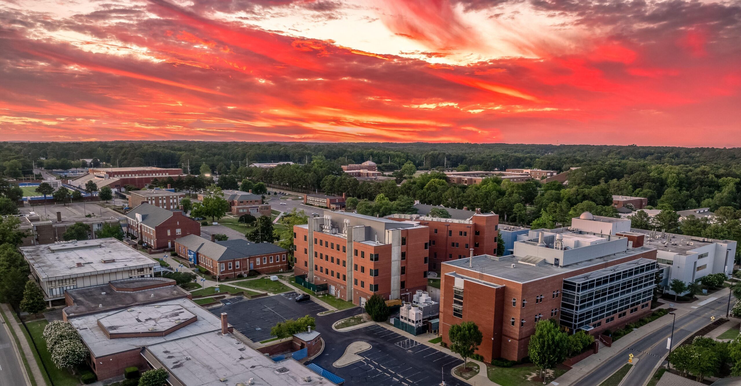 Aerial view of Fayetteville State University administration building with dramatic colorful sunset sky.