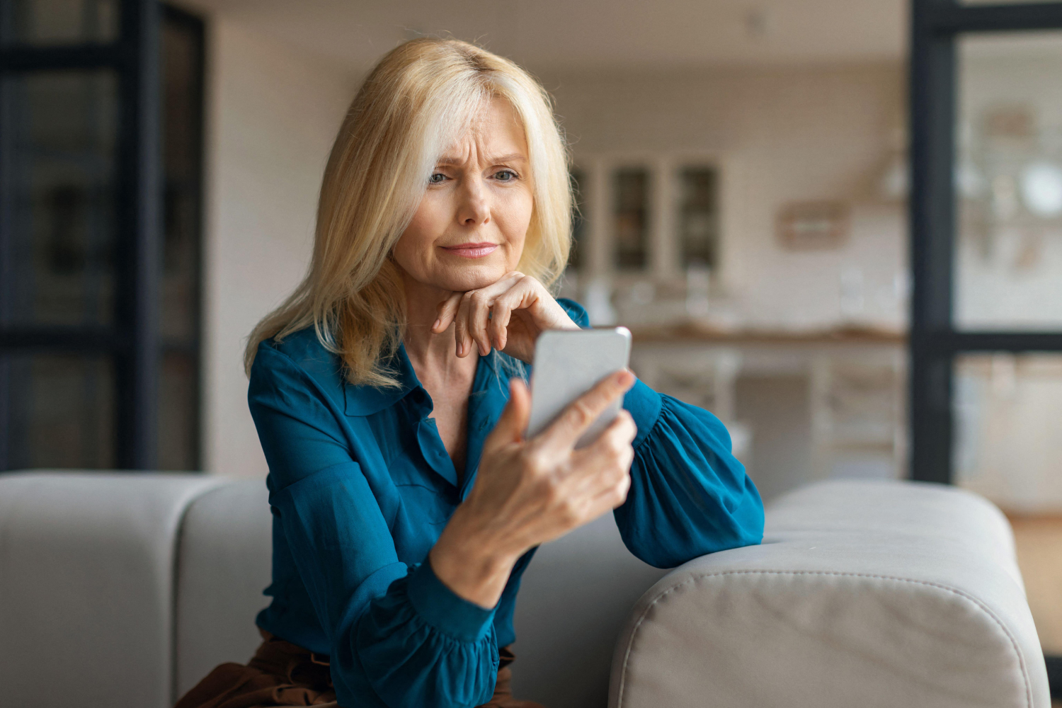 Woman staring at her phone in concern.